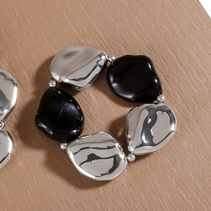 Makroaufnahme von silbernen und schwarzen kieselsteinförmigen Stretch-Armband-Details