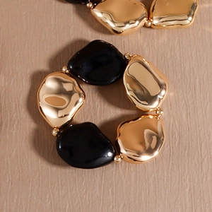 Detailansicht eines elastischen Perlenarmbands mit klobigen gold-schwarzen Kieselsteinen
