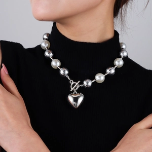 Détail du fermoir à bascule OT et pendentif coeur sur collier de perles larges