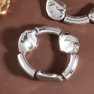 Makroansicht des klobigen silbernen Stretch-Armbands mit geschmolzener Lava-Metall-Textur