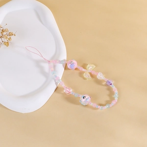Close-up of pink beaded phone charm with yellow bow, heart beads and smiley patterns