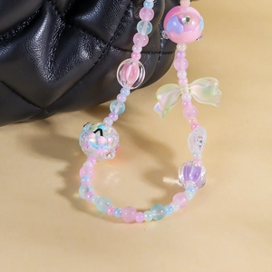 Macro detail of colorful macaron beaded phone strap featuring heart and bow charms