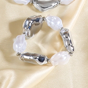 Details des goldenen Stretch-Armbands mit abwechselnd silbernen und Perlen-Perlen