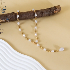 Collar largo de perlas barrocas en forma de Y con detalles dorados sobre rama