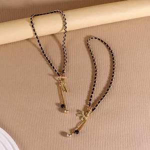 Vintage gold woven necklace with black velvet ribbon, OT buckle, and tassel pendant detail