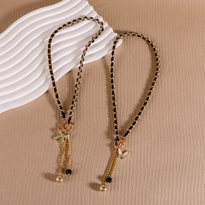 Vintage gold metal necklace with black velvet bow and heart pendant featuring tassels