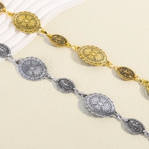 Detail of vintage gold and silver metal waist chains with ornate embossed medallions