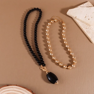 Detail of vintage beaded necklaces with a large black teardrop pendant and golden OT clasp