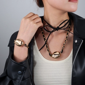 Dettaglio della collana in velluto e bracciale con perle dorate indossati da modella
