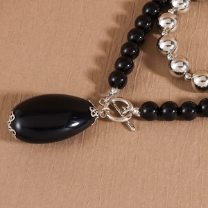 Macro detail of beaded necklace with oval black gemstone pendant and vintage OT toggle clasp