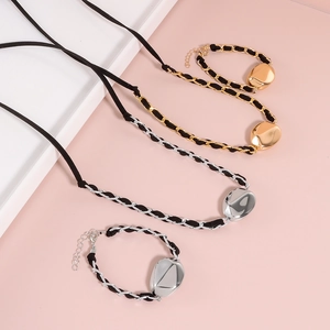 Set gioielli con ciondolo metallico irregolare e corda intrecciata nera