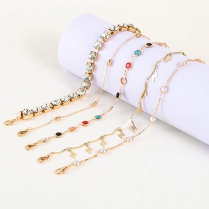 Juego de cinco tobilleras doradas de varias capas con borlas, cristales y perlas