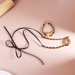 Dettaglio della collana con fiocco in velluto e set bracciale in oro intrecciato