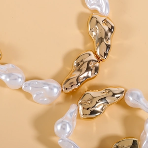 Vue macro détaillée de perles baroques et d'éléments métalliques dorés texturés