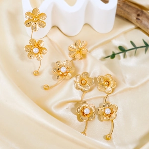 Detailansicht der goldene Blumen-Ohrringe mit weißen Perlen und gehämmerter Oberfläche