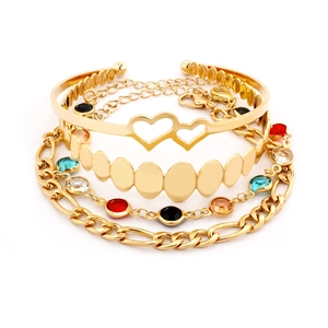Dettaglio di set di quattro bracciali dorati con pietre colorate e cuori traforati