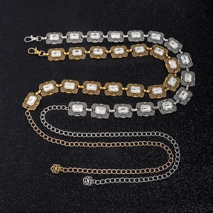 Detail von Vintage-Kettengürteln in Gold und Silber mit Kristallen und Rosenanhänger