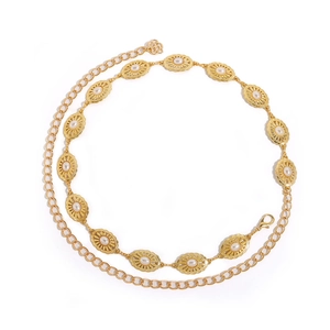 Close-up of golden belt chain with oval medallion links and white pearl inlays
