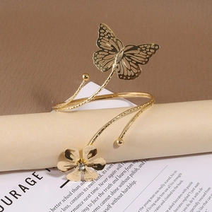 Détail du bracelet de bras doré avec papillon et fleur en strass sur un rouleau