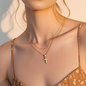 Elegant gold double layer necklace with a sparkling cubic zirconia cross pendant on model