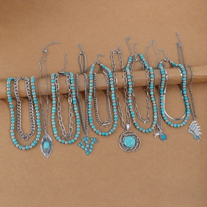 Detail view of bohemian turquoise necklace set with silver alloy feather and moon pendants