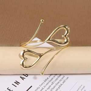 Gros plan du bracelet de bras doré avec double cœur et design spirale ajustable