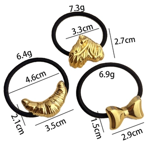 Élastiques à cheveux avec pendentifs dorés en forme de cœur, de lune et de nœud sur fond blanc