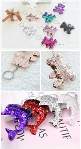 Detailed view of sequined bear and dolphin keychains in various colorful finishes