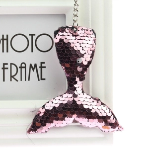 Macro detail of mermaid tail keychain with pink reversible sequins and silver chain link