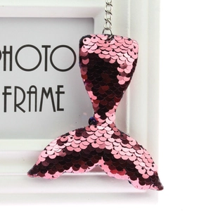Detail of pink sequin mermaid tail keychain pendant with silver metal chain accessory