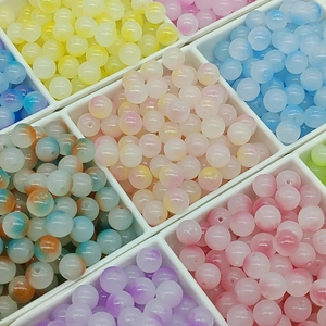 Macro shot of colorful 10mm gradient glass beads arranged in white storage grid