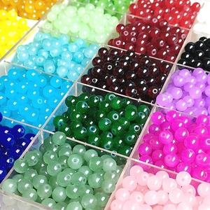 Macro shot of 8mm and 10mm colorful glass beads organized in a transparent grid storage box