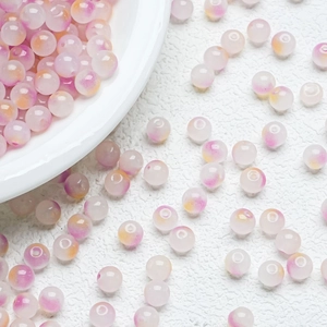 Close-up of pink and yellow gradient round glass beads for DIY jewelry making