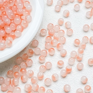 Close-up of 8mm round gradient glass beads in peach and orange for DIY jewelry making