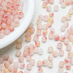 Macro shot of pink and yellow gradient glass beads with polished jelly texture