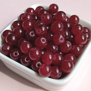 Macro detail of 8mm wine red translucent glass beads for DIY jewelry making