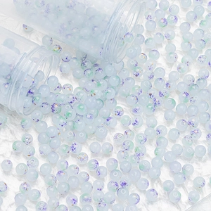 Detail of 8mm blue gold-flecked glass beads for DIY jewelry making on white background
