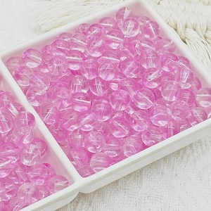 Détails de perles de verre rose avec texture craquelée dans un plateau blanc