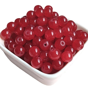 Polished dark red glass round beads for DIY jewelry making in a white ceramic bowl