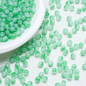 Macro shot of 6mm translucent light green gradient jade-like glass beads for DIY jewelry