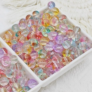 Vue détaillée de perles de verre aurora colorées 6-10 mm dans un plateau blanc pour bijoux