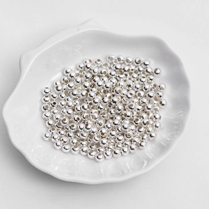 Polished silver metal loose beads for DIY jewelry making displayed in a shell dish