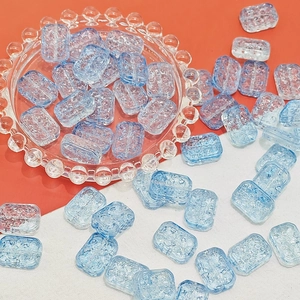Macro detail of light blue translucent 13x18mm double-sided embossed glass beads for DIY