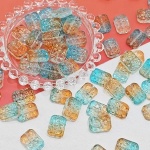 Macro detail of 13x18mm double-sided glass beads with blue and amber orange gradient