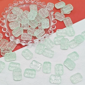 Macro detail of light green translucent flower beads with double-hole design for DIY jewelry