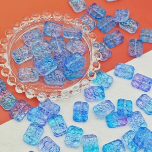 Detailed macro view of 13x18mm gradient glass flower beads with 3D embossed texture