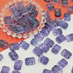 Macro detail of 13x18mm purple translucent glass flower beads for DIY jewelry making