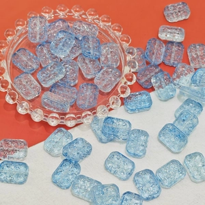 Detailed macro view of light blue translucent glass beads with irregular ripple texture