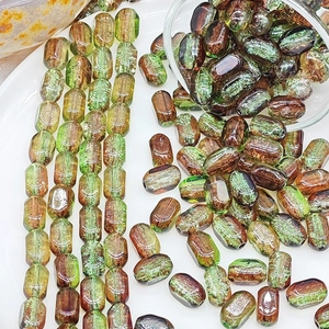 Close-up of 6x10mm marbled green and brown glass beads with holes for DIY jewelry