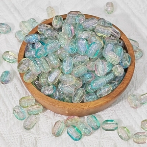 Detailed view of iridescent rectangular glass beads with AB coating in a wooden tray